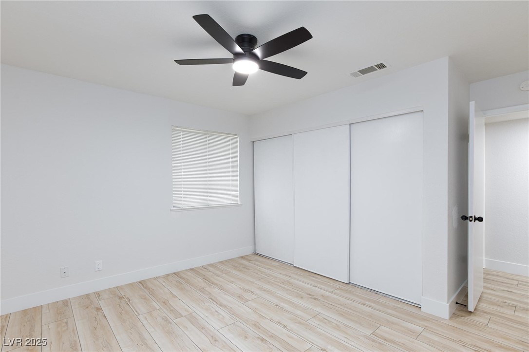 5905 Smoke Ranch Road, Unit A Las Vegas, NV 89108 - Photo 24 of 31 Unfurnished bedroom with light wood-type flooring, ceiling fan, and a closet