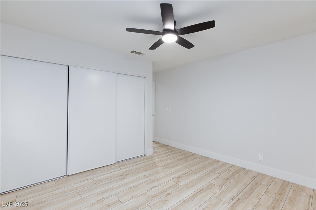 5905 Smoke Ranch Road, Unit A Las Vegas, NV 89108 - Photo 25 of 31 Unfurnished bedroom with light wood-style floors, a closet, and ceiling fan