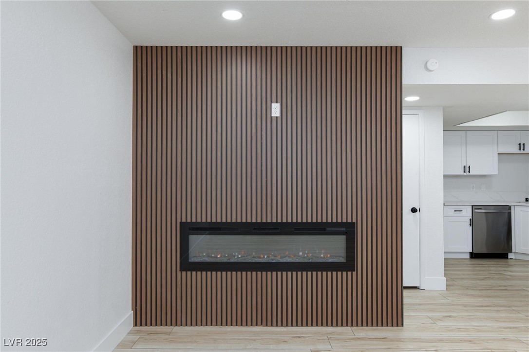 5905 Smoke Ranch Road, Unit A Las Vegas, NV 89108 - Photo 5 of 31 Detailed view of a glass covered fireplace, recessed lighting, stainless steel dishwasher, and wood finished floors