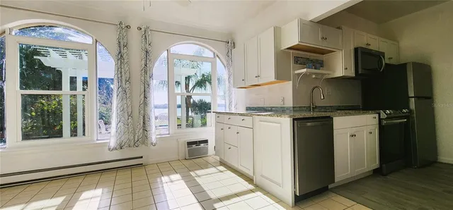 a kitchen with a refrigerator and countertop cabinets