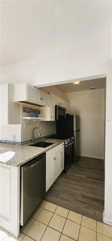 a kitchen with stainless steel appliances granite countertop a sink and a stove