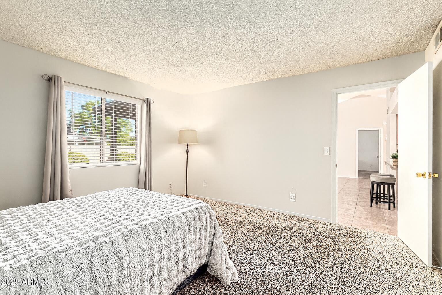 1312 East Stephens Drive Tempe, AZ 85283 - Photo 17 of 26 a bedroom with a bed and a dresser with rug