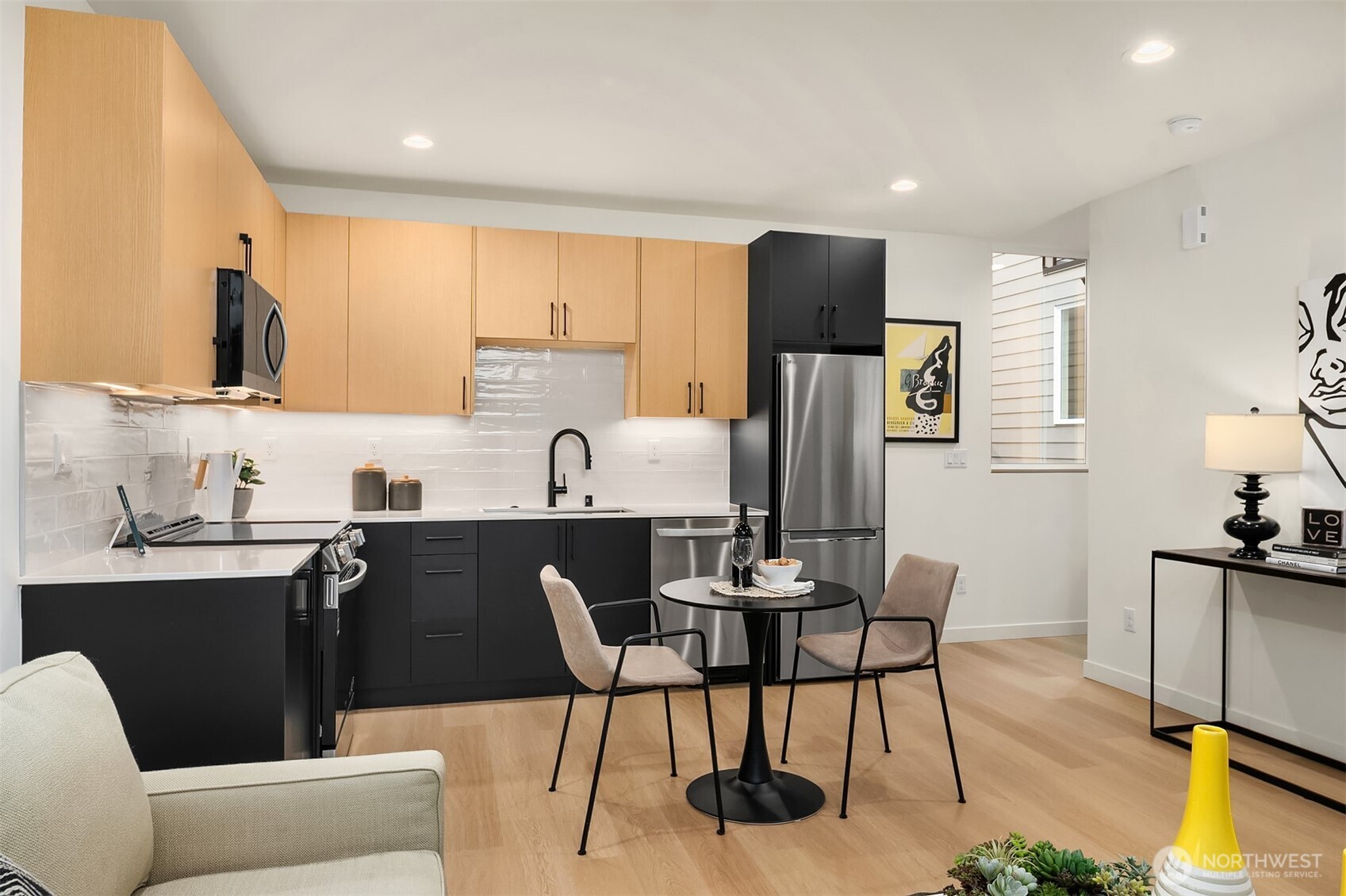 1457 22nd Avenue, Unit A Seattle, WA 98122 - Photo 5 of 15 a kitchen with stainless steel appliances granite countertop a sink a stove a refrigerator a dining table and chairs
