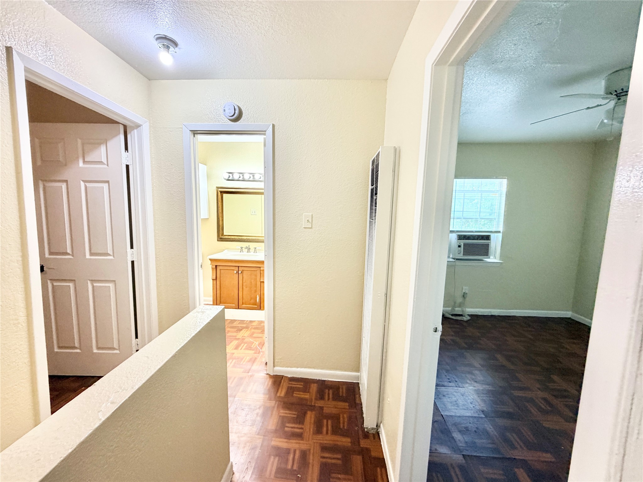 6257 Manor Road, Unit B Austin, TX 78723 - Photo 28 of 38 Hallway featuring patterned wood-finish flooring, light cream wall paint, and a built-in wall heater