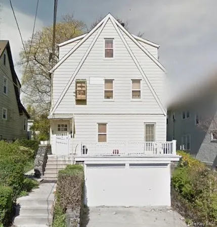 a view of house that has wooden fence and large windows