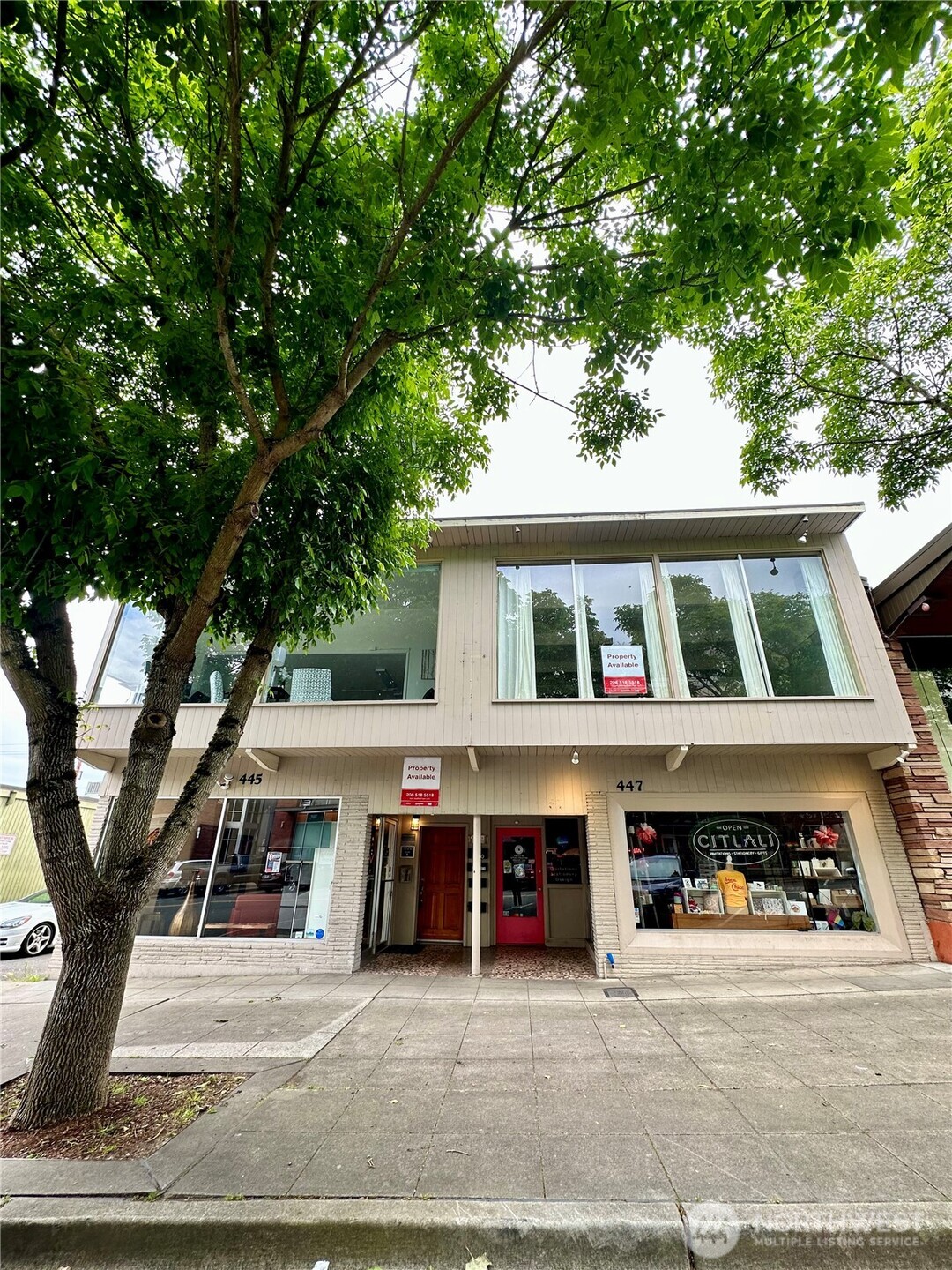 447 Southwest 152nd Street, Unit 206 Burien, WA 98166 - Photo 2 of 17 a view of a white house with large trees