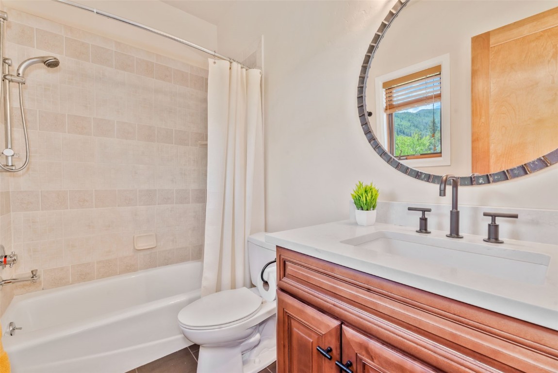 2911 Inverness Way Steamboat Springs, CO 80487 - Photo 36 of 43 a bathroom with a granite countertop toilet a sink and a bathtub