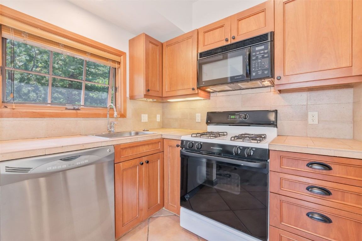 2911 Inverness Way Steamboat Springs, CO 80487 - Photo 41 of 43 a kitchen with granite countertop a stove top oven cabinetry a sink and a window
