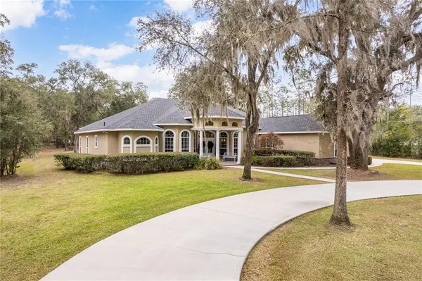a front view of a house with a yard and trees