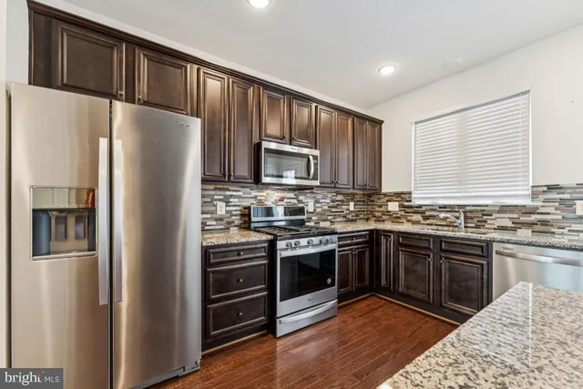 a kitchen with granite countertop stainless steel appliances and wooden cabinets