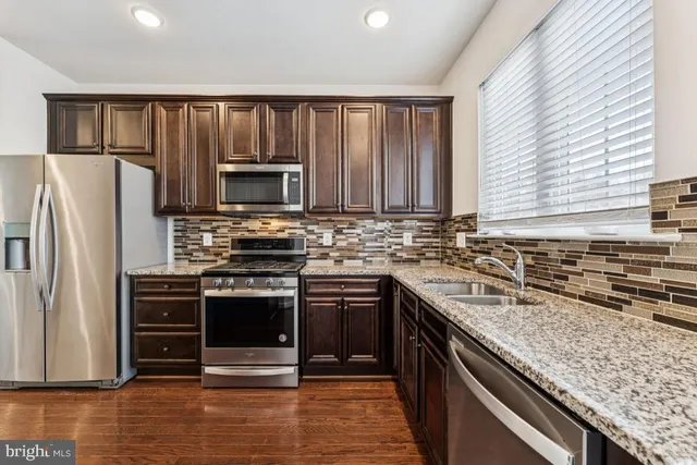 a kitchen with granite countertop a stove and a refrigerator