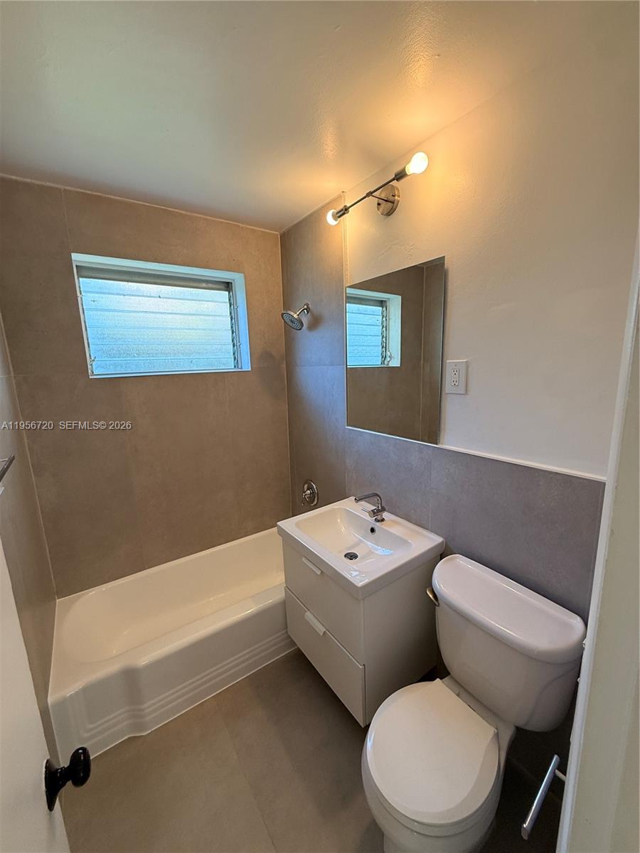 2538 Southwest 11th Street, Unit 2 Miami, FL 33135 - Photo 7 of 14 a bathroom with a toilet sink and mirror
