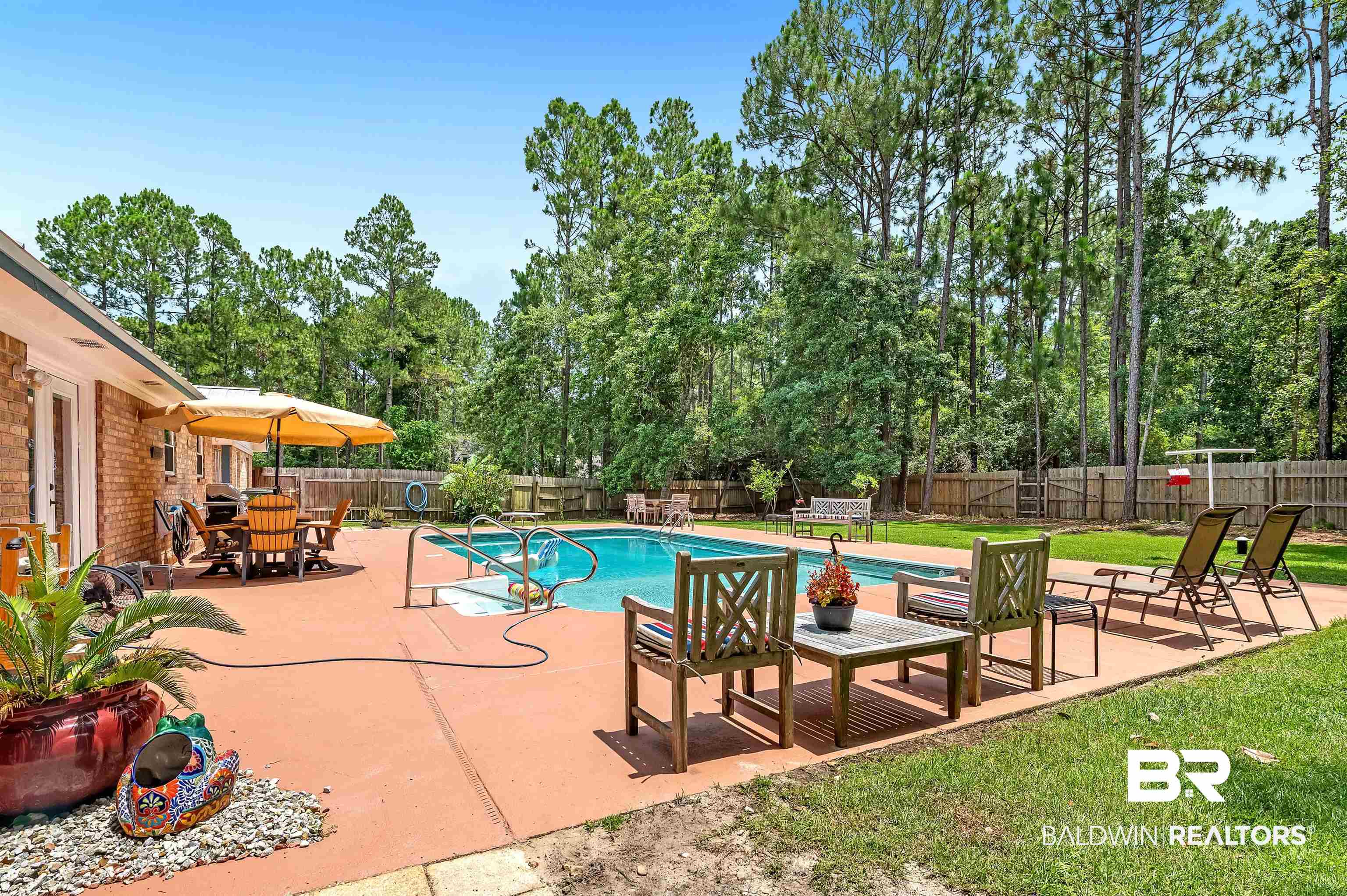 24551 Wolf Bay Drive Foley, AL 36535 - Photo 9 of 59 View of pool featuring a fenced backyard, a patio, outdoor dining area, and view of scattered trees