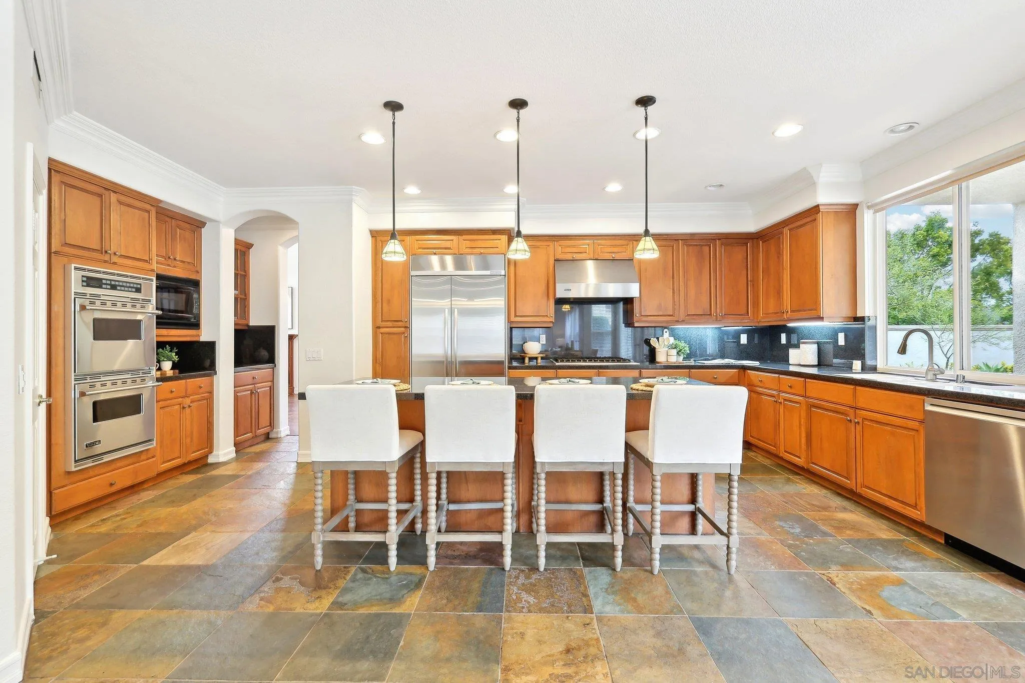 11781 Treadwell Drive Poway, CA 92064 - Photo 11 of 63 a kitchen with stainless steel appliances kitchen island granite countertop a table and chairs