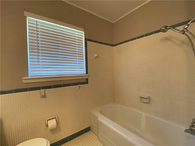 a bathroom with a granite countertop sink toilet and bathtub
