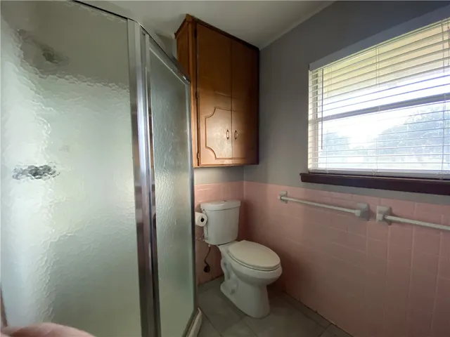 a bathroom with a toilet a sink and a window
