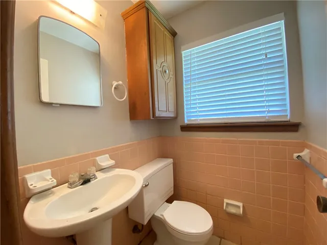 a bathroom with a sink a toilet and mirror
