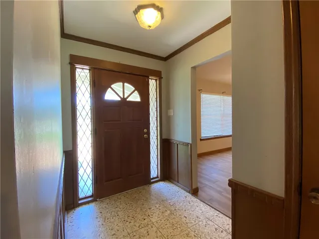 an entryway with wooden floor and stairs