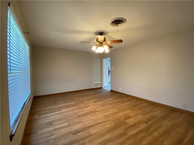 a view of an empty room with a chandelier fan