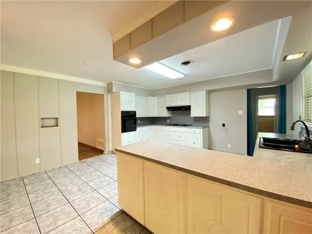 a large white kitchen with kitchen island a sink a stove and a refrigerator
