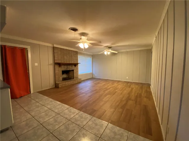 an empty room with a fireplace and cabinet