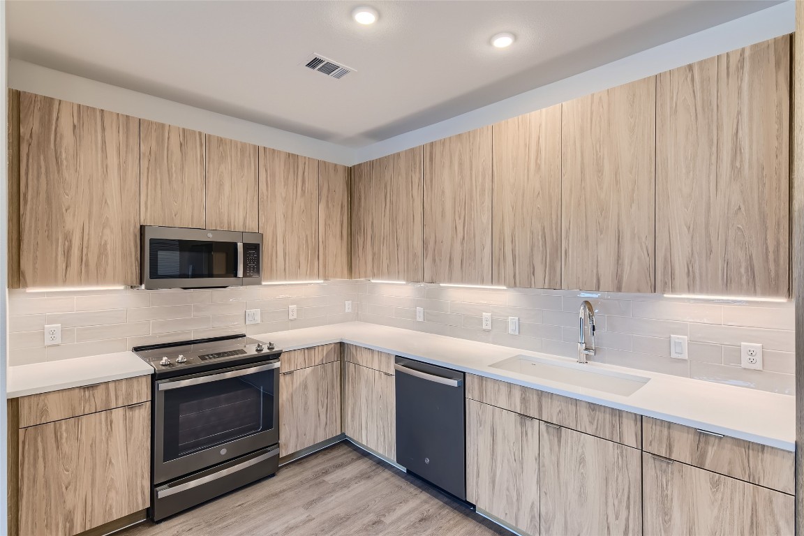 4802 South Congress Avenue, Unit 305 Austin, TX 78745 - Photo 15 of 25 a kitchen with a sink stove and microwave