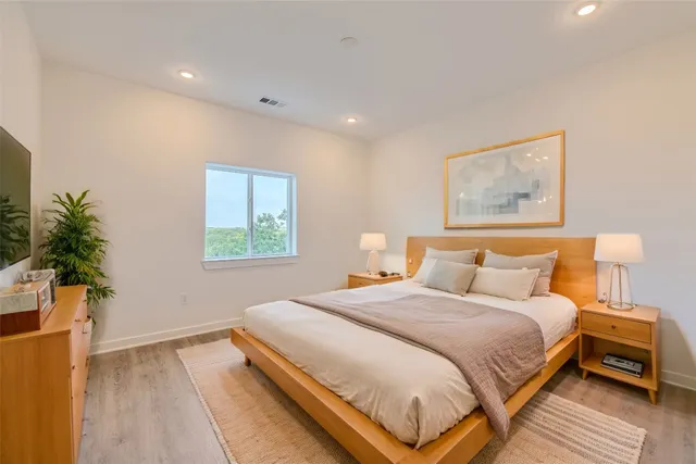 a bedroom with a bed and a painting on the wall