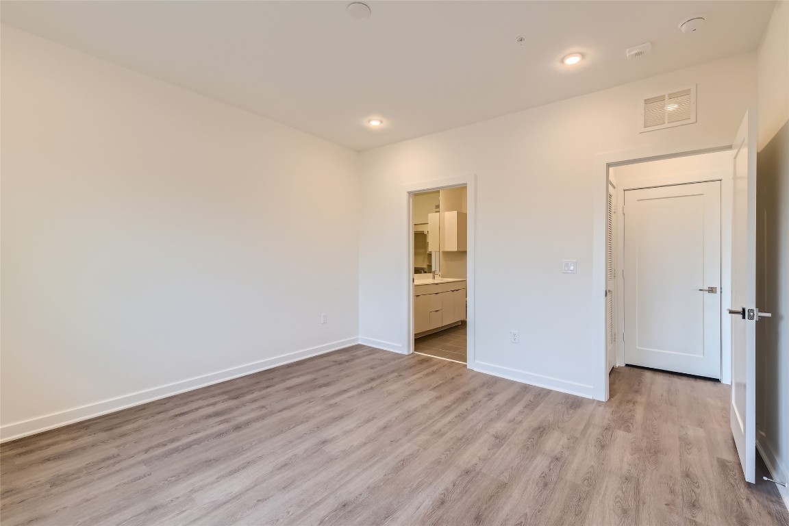 4802 South Congress Avenue, Unit 305 Austin, TX 78745 - Photo 6 of 25 a view of an empty room with wooden floor and closet