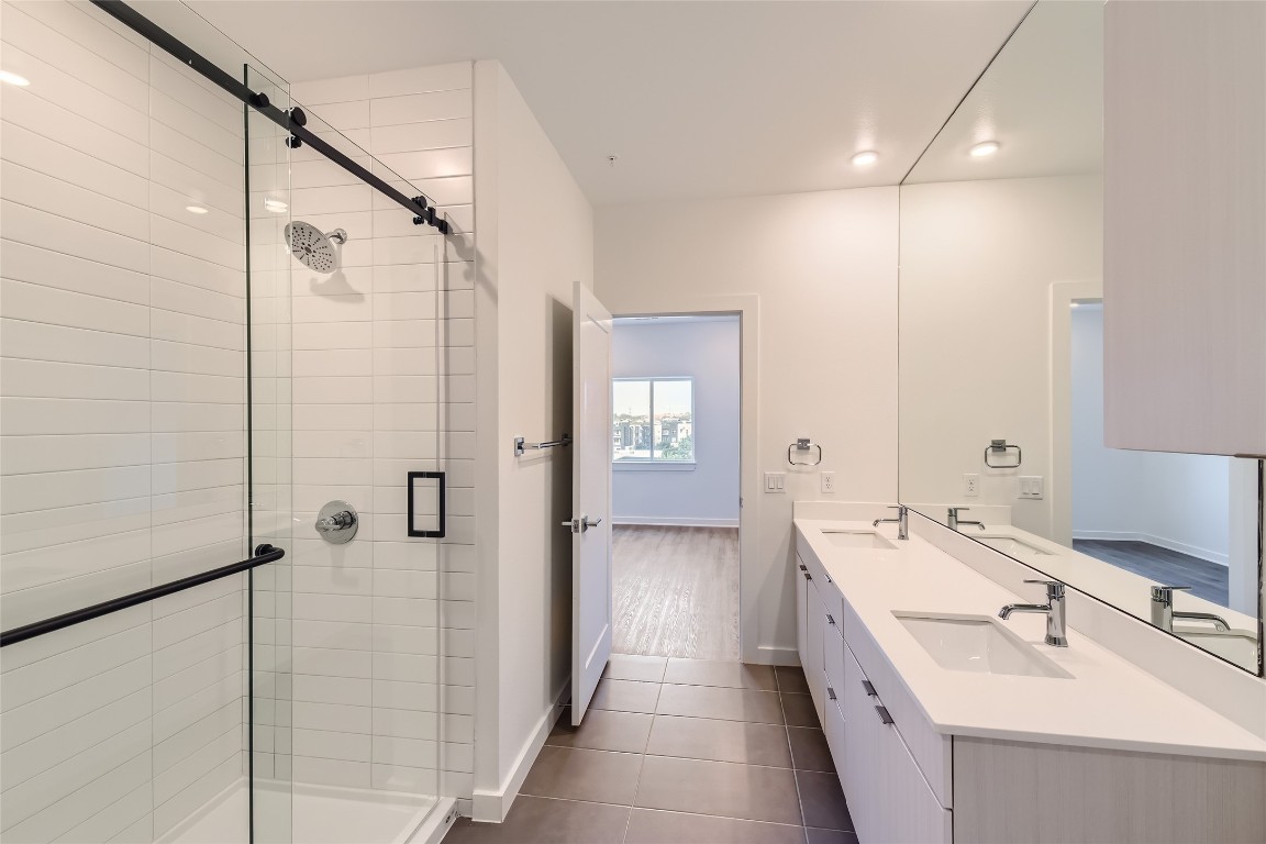 4802 South Congress Avenue, Unit 305 Austin, TX 78745 - Photo 8 of 25 a bathroom with a double vanity sink a mirror and shower