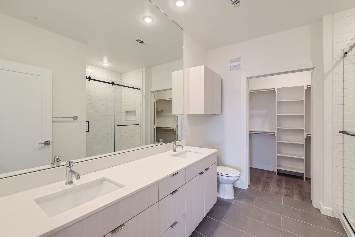 4802 South Congress Avenue, Unit 305 Austin, TX 78745 - Photo 8 of 25 a bathroom with a double vanity sink mirror and toilet
