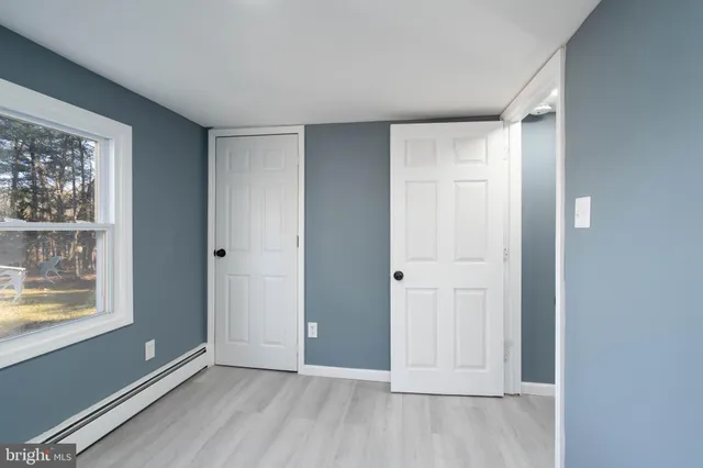 an empty room with windows and closet