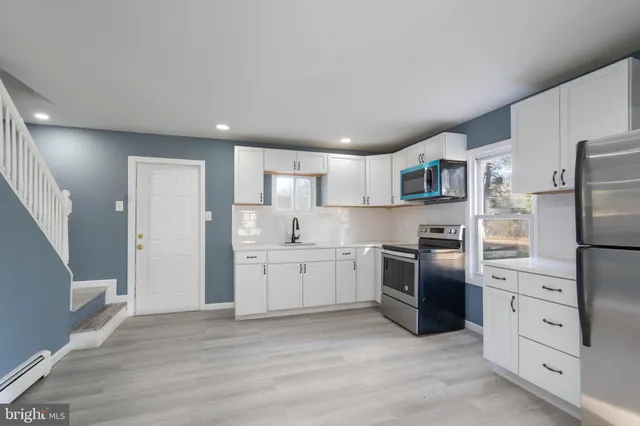 a kitchen with white cabinets and stainless steel appliances