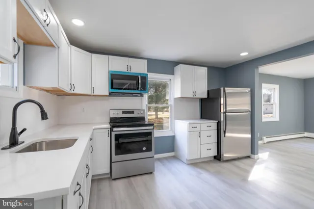 a kitchen with white cabinets and stainless steel appliances