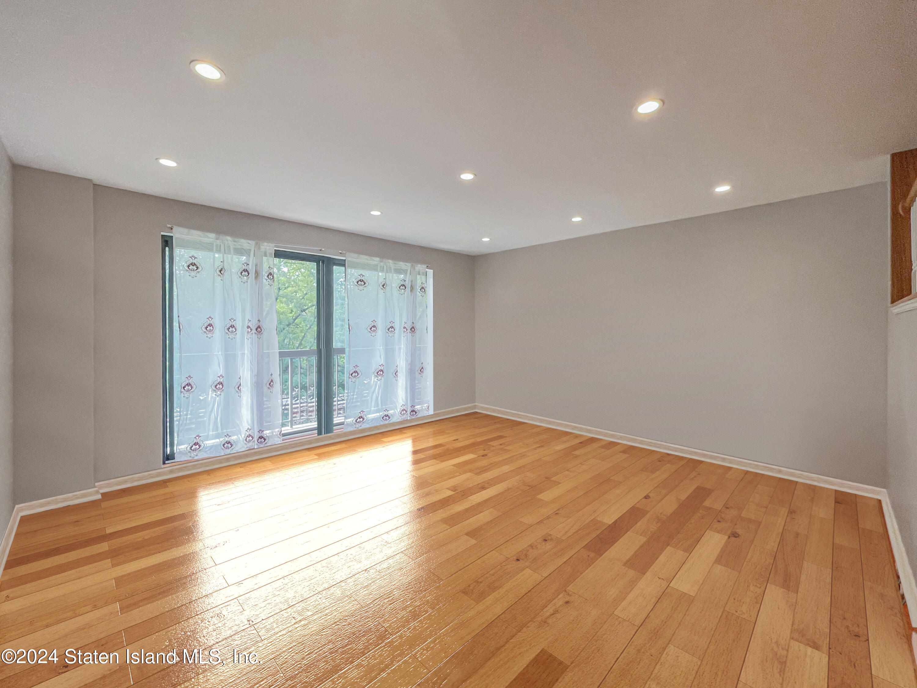 175 Zoe Street, Unit 5S Staten Island, NY 10305 - Photo 13 of 15 a view of an empty room with wooden floor and a window