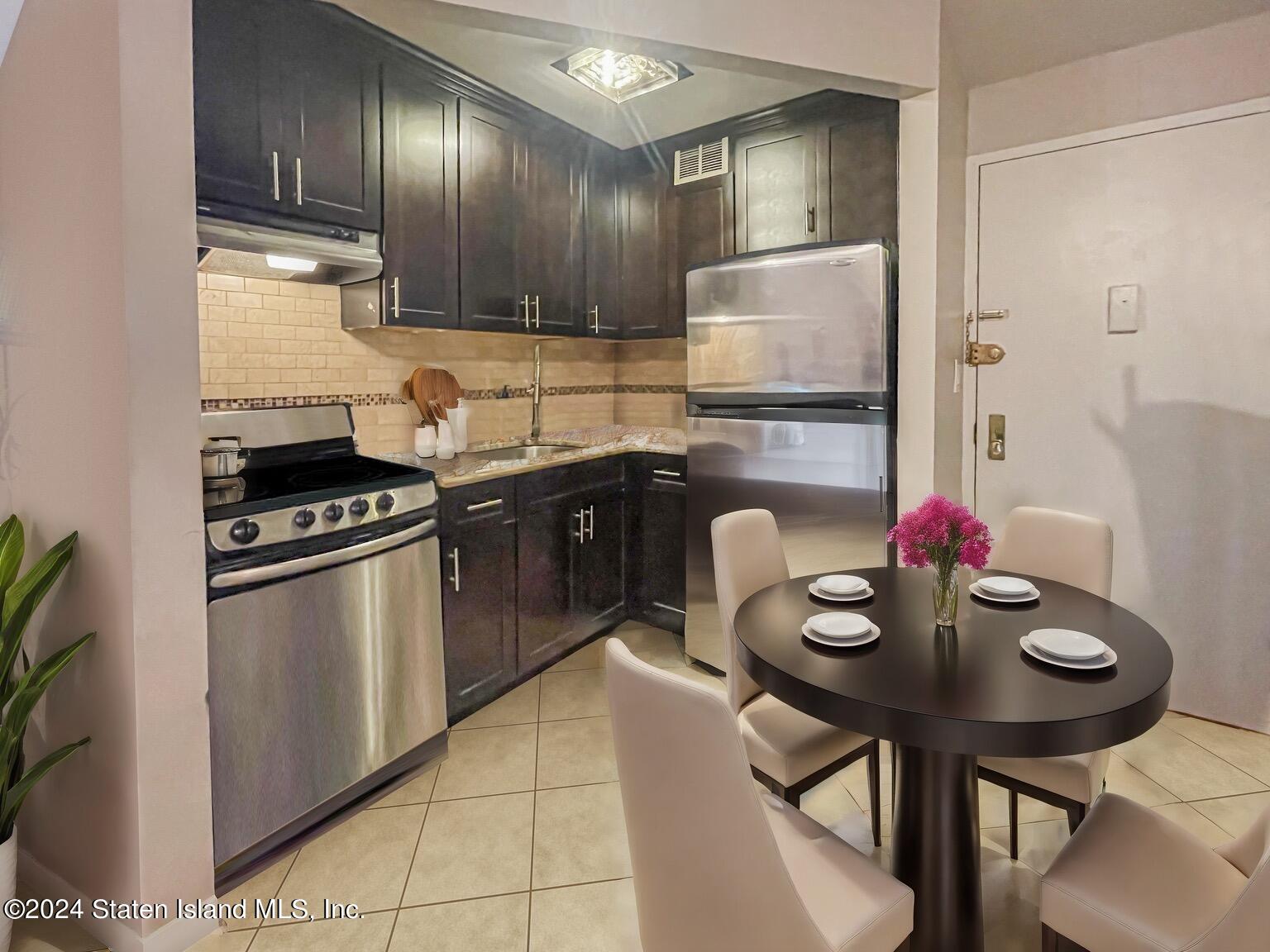 175 Zoe Street, Unit 5S Staten Island, NY 10305 - Photo 7 of 15 a kitchen with stainless steel appliances granite countertop a sink stove and refrigerator
