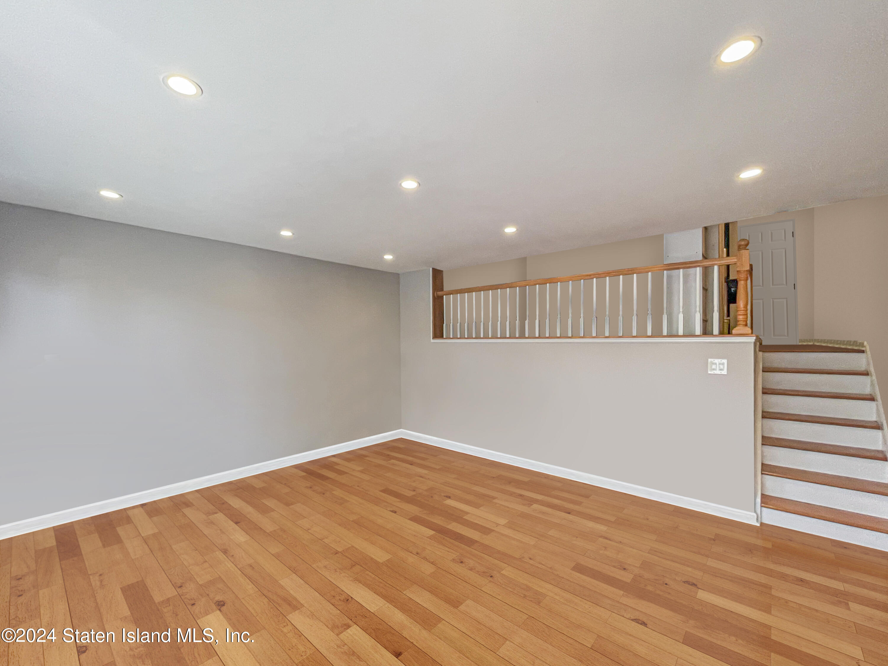 175 Zoe Street, Unit 5S Staten Island, NY 10305 - Photo 10 of 15 an empty room with wooden floor and windows