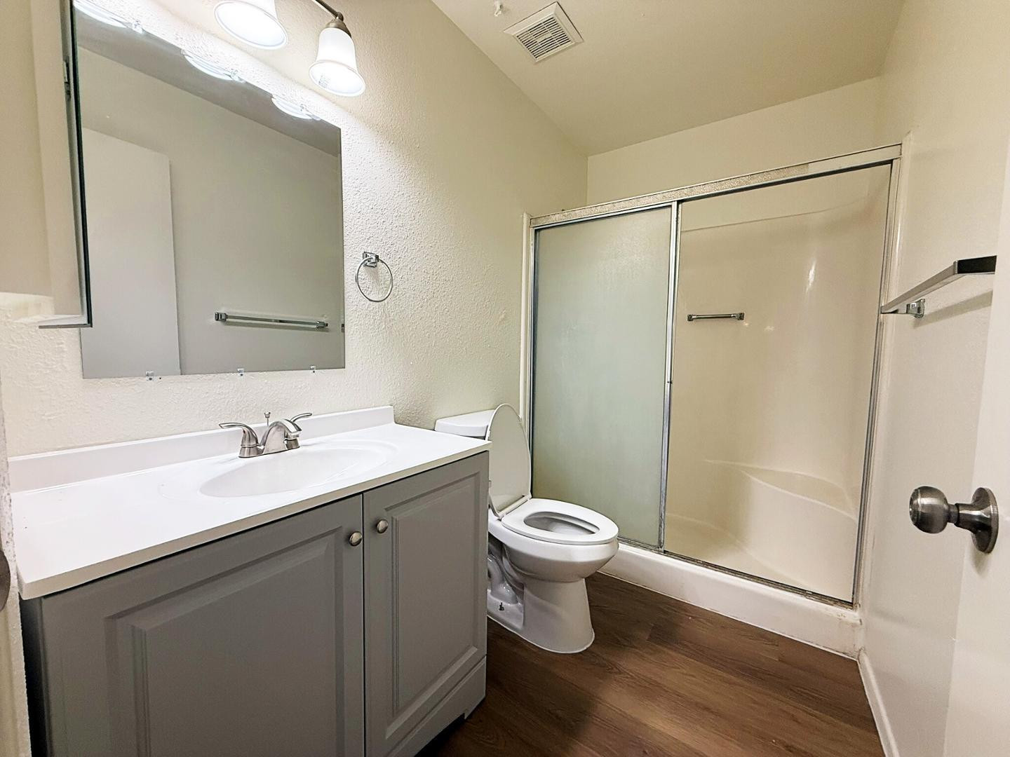 a bathroom with a sink toilet a mirror and shower