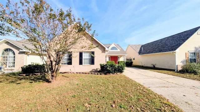 a front view of a house with a yard covered in snow