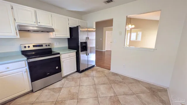 a kitchen with a stove top oven and cabinets