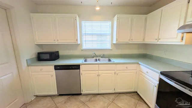 a kitchen with white cabinets and white appliances