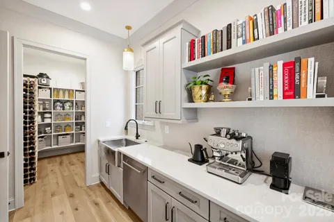a kitchen with refrigerator and wooden floor