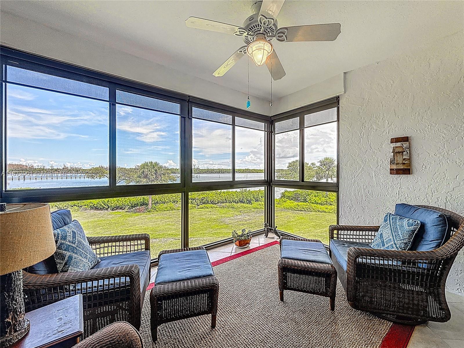 6082 Southeast Landing Way, Unit 11 Stuart, FL 34997 - Photo 30 of 57 a living room with furniture and floor to ceiling windows
