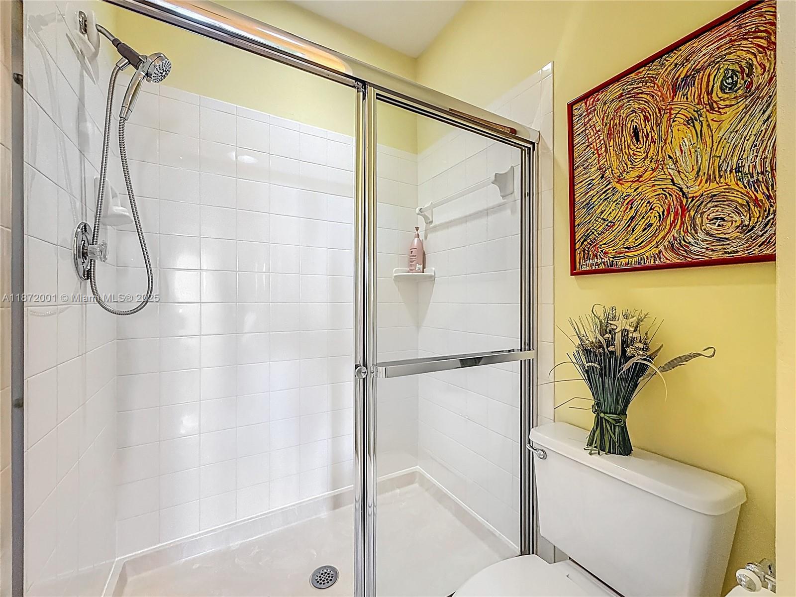 6082 Southeast Landing Way, Unit 11 Stuart, FL 34997 - Photo 37 of 57 a bathroom with a shower a toilet and a shower