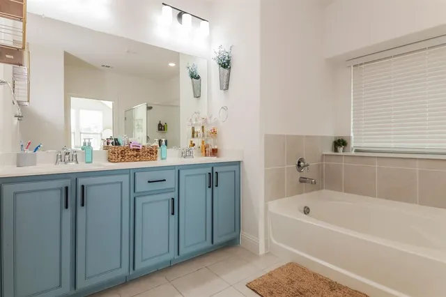a bathroom with a tub sink and mirror
