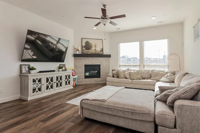 a living room with furniture a flat screen tv and a fireplace
