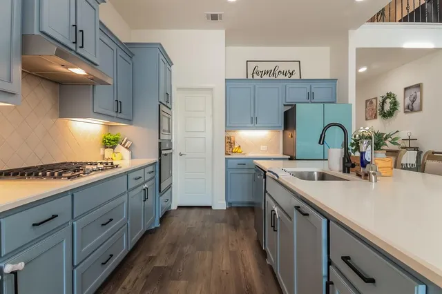 a kitchen with sink stove and refrigerator