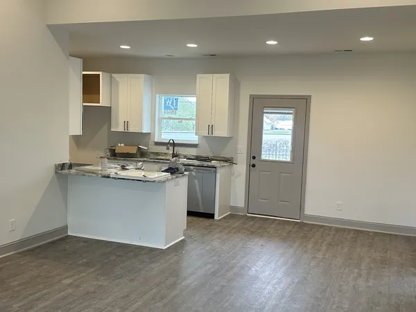 a kitchen with granite countertop a sink and cabinets