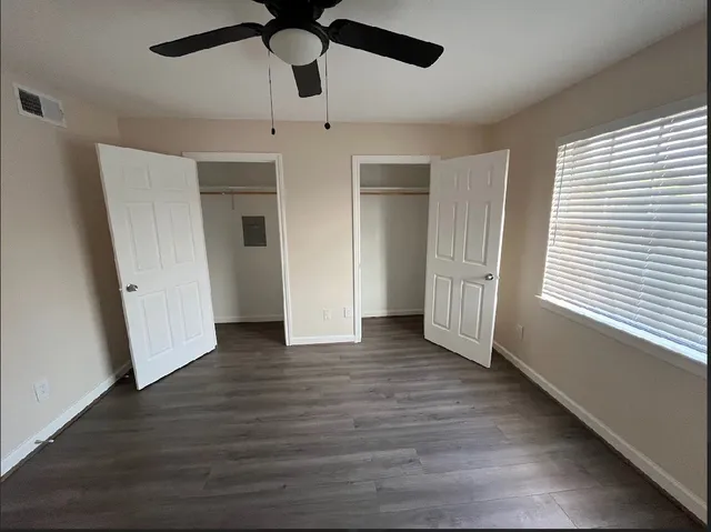 a view of empty room with wooden floor and window