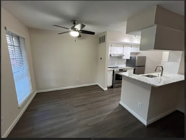 a view of kitchen with sink wooden floor and electronic appliances