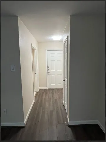 a view of a hallway with wooden floor